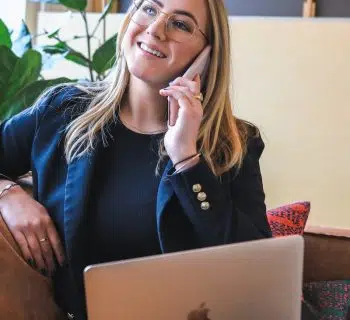woman in blue long sleeve shirt sitting on brown couch